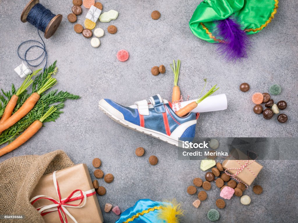 Dutch holiday Sinterklaas background Dutch holiday Sinterklaas background with gifts, pepernoten, sweets and childrens shoe with carrots for Santa's horse. Flat lay with copy space. Top view. Sinterklaas Stock Photo