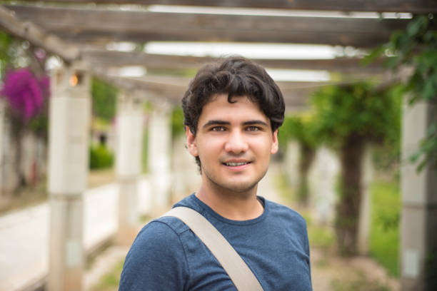 istock Portrait of young university student looking at camera by smiling in campus 856936736