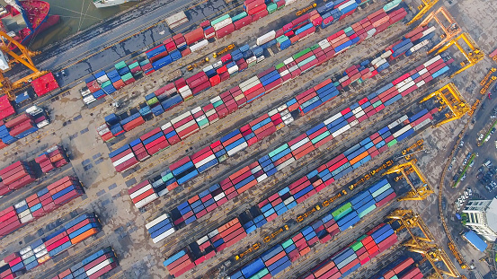 Container Cargo freight ship with working crane bridge in shipyard