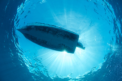 boat photographed in clear water from underneath