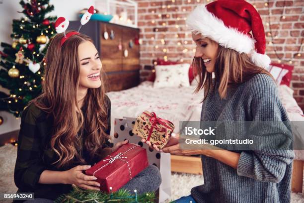 Friends Presenting Gifts Each Other In Bedroom Stock Photo - Download Image Now - Christmas Present, Gift, Women