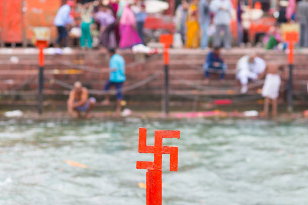 インドのハリドワールにあるガンジス川の赤いスワスティカは、ヒンドゥー教の宗教の聖地です。ガーツ山脈で入浴する巡礼者。 - indian ethnicity traditional culture architecture karnataka ストックフォトと画像