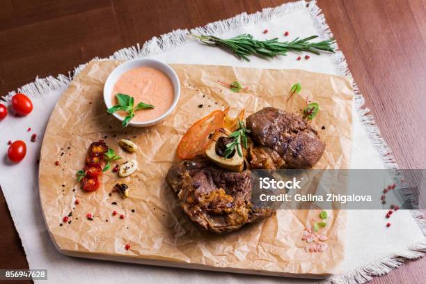 The Large Roasted Piece Of Meat On The Bone With Sauce And Spices On Wooden Board View From Top Stock Photo - Download Image Now