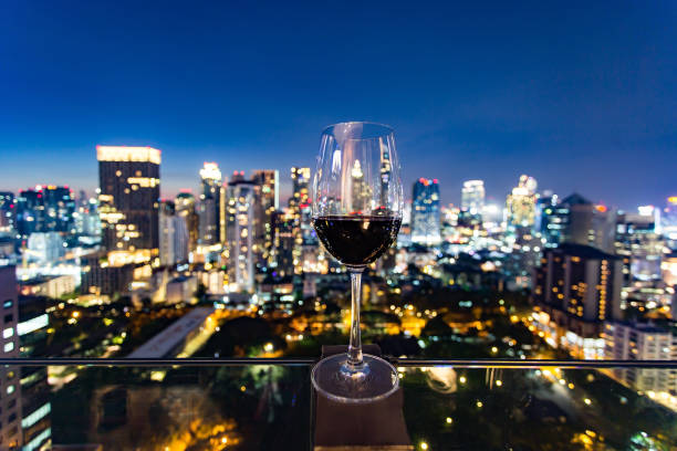 istock Wine glass with red wine in city bokeh background 856948346