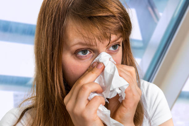 istock Sick woman having flu and sneezing into handkerchief 856949402