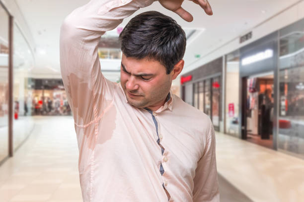 istock Man with sweating under armpit in shopping center 856949424