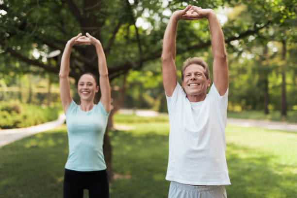 istock Couple doing exercises in the park. They do stretching hands 856951836