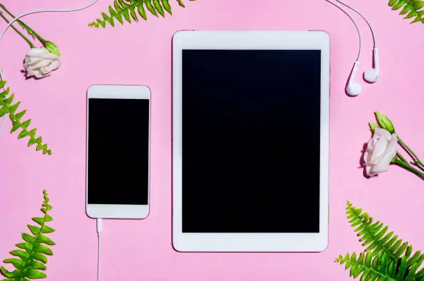 Photo of Mobile and digital tablet on pink