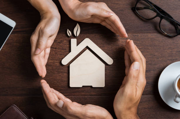 House care Top view of hands of a couple protecting their ecologigal house on wooden background. High angle view of hand of man and woman covering house shape. New home, Insurance and security concept. green home decor stock pictures, royalty-free photos & images