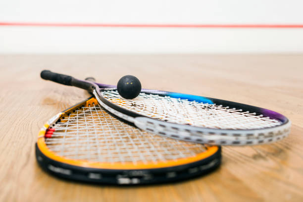 istock Squash racket and ball on the court ,leaning on wall 856956164