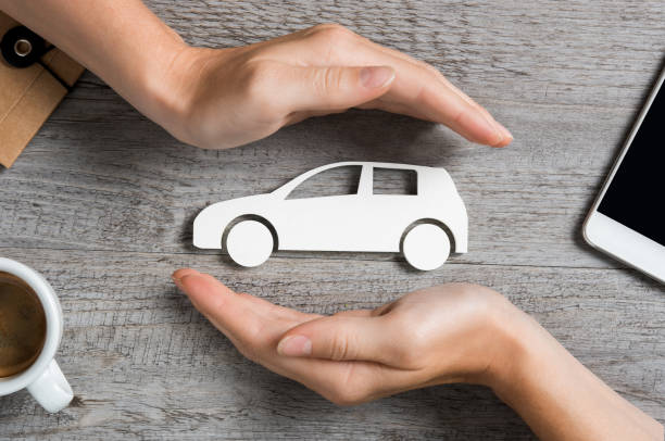 Car insurance concept Hands protecting icon of car over wooden table. Top view of hands showing gesture of protecting car. Car insurance and automotive business concept. car insurance photos stock pictures, royalty-free photos & images