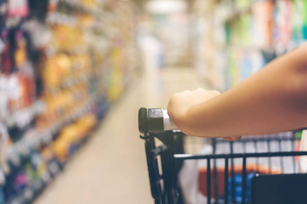 istock Asian woman's hand with supermarket, trolley and many objects that are blurred background.This image is blurred and Soft focus. 856967842