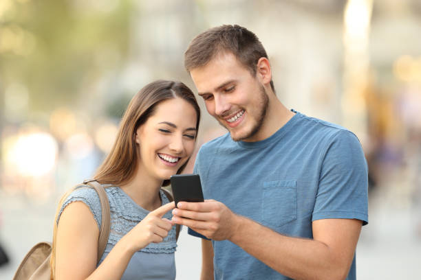 istock Happy couple using a smart phone on the street 856968894