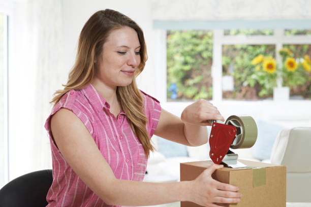 istock Woman At Home Sealing Box For Dispatch 856970192