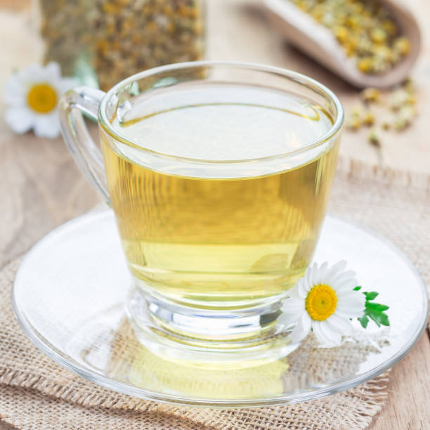 istock Chamomile tea in a glass cup, chamomile flowers and dry tea on background, square format 856972810