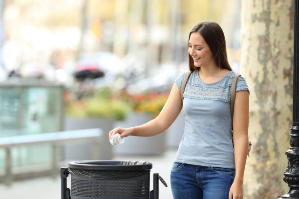 istock Civic woman throwing a paper into a trash bin 856974498