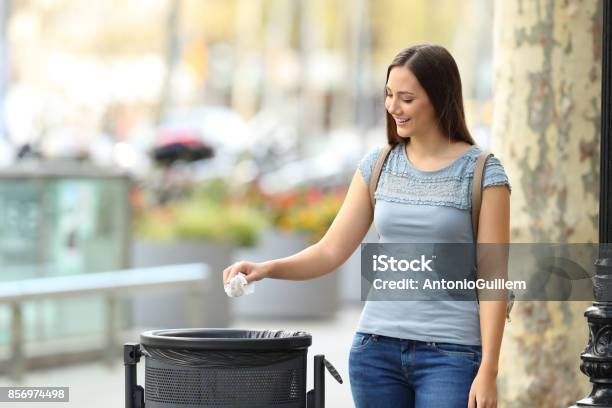 Civic Woman Throwing A Paper Into A Trash Bin Stock Photo - Download Image Now - Garbage, Throwing, Cleaning