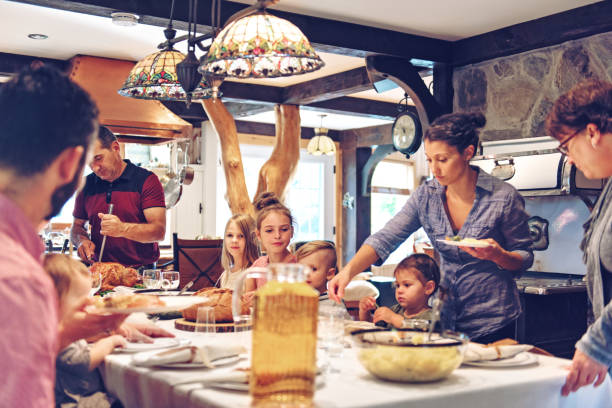 Holiday Season Family helping each other to prepare holidays dinner big family table stock pictures, royalty-free photos & images