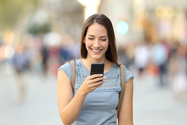 istock Front view of a woman using a smart phone on the street 856978788