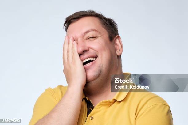 Caucasian Fat Man Laughs And Covers His Face With His Hands Stock Photo - Download Image Now