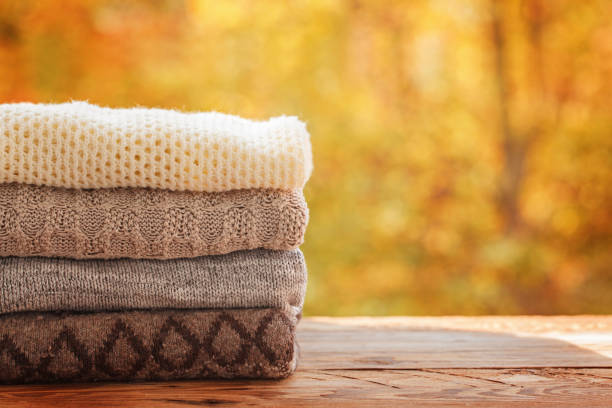 istock Stack pile of knitted autumn clothes on nature background. 856979782