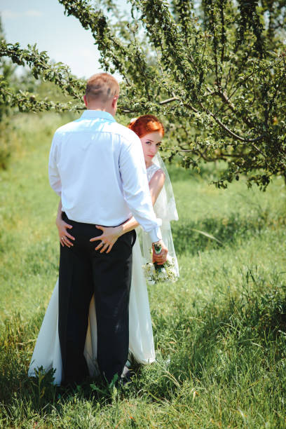 istock Bride and groom hold each other hands while they walk along the 856984020