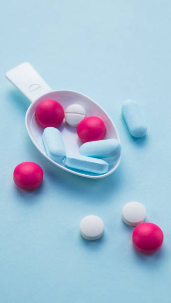 istock colorful color pills in the tablespoon on blue background 856989800
