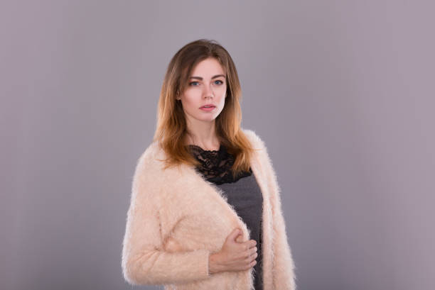 istock Young woman standing in jeans and light sweater 856993280