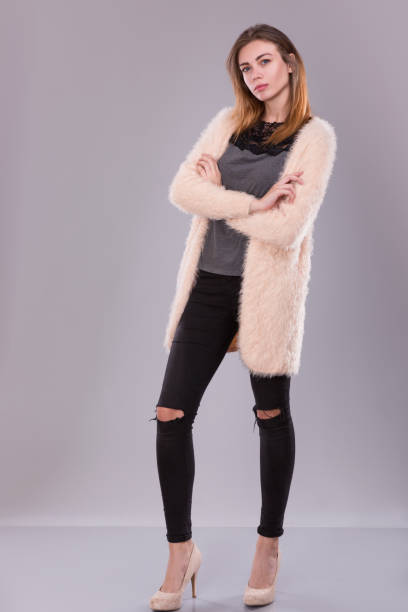 istock Young woman standing in jeans and light sweater 856993392