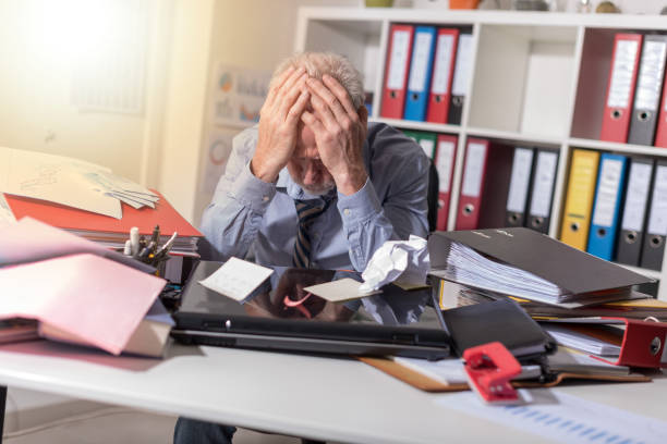istock Overworked businessman sitting at a messy desk, light effect 856995868
