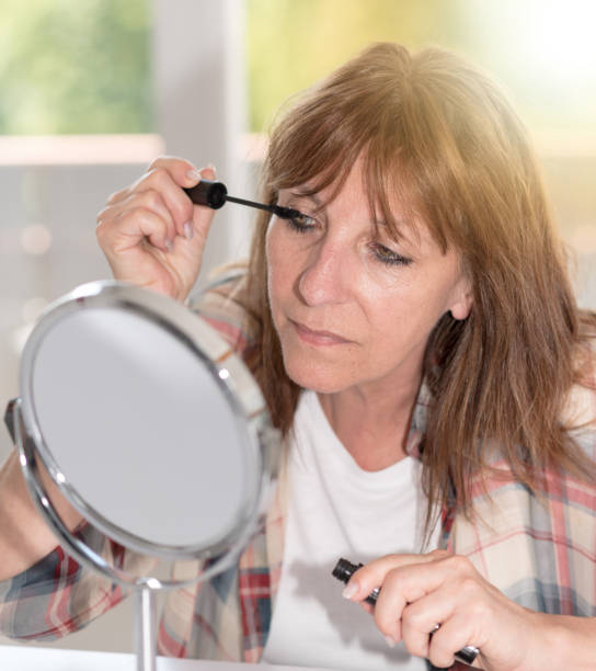 istock Woman applying mascara on her eyelashes, light effect 856996402