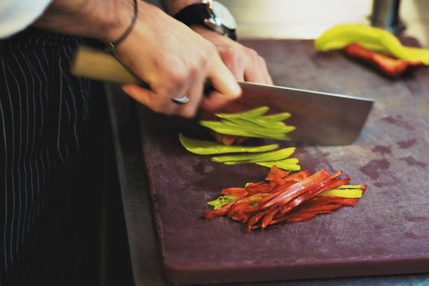 istock caucasian man is chopping the peppers with a big knife. 857001006