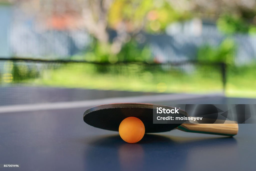 Tenis de mesa con la raqueta y naranja bola en patio trasero - Foto de stock de Tenis de mesa libre de derechos