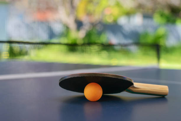 table de ping-pong avec raquettes et orange ball sur l’arrière-cour - table tennis table tennis racket racket sport ball photos et images de collection