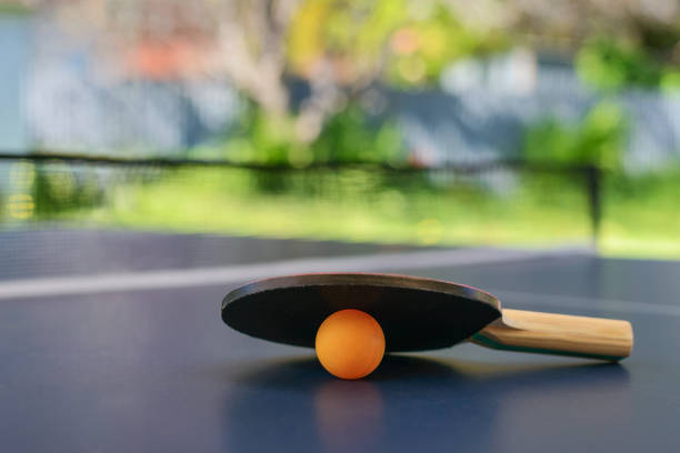 tavolo da ping pong con racchetta e palla arancione sul cortile - table tennis table tennis racket racket sport ball foto e immagini stock