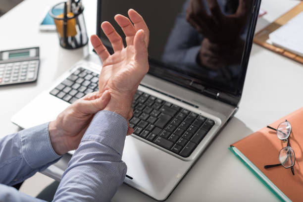 Businessman suffering from wrist pain Businessman suffering from wrist pain in office carpal tunnel syndrome photos stock pictures, royalty-free photos & images