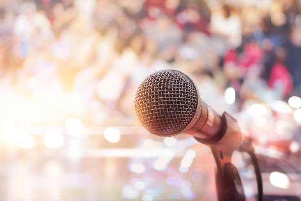 istock Microphone on stage in concert with people background 857015142