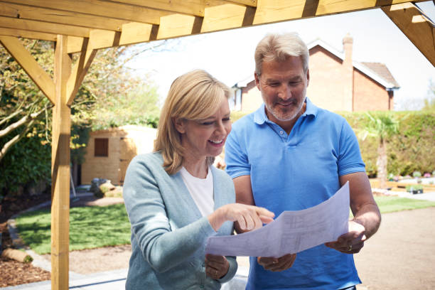 istock Mature Woman Looking At Design Plan With Landscape Gardener 857016850