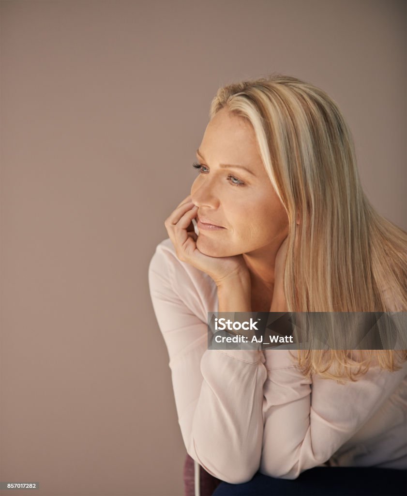 Life has its challenges, but it's still beautiful nonetheless Studio shot of a mature woman looking thoughtful against a brown background 30-39 Years Stock Photo