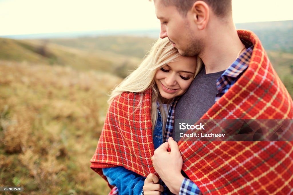 Happy couple under a plaid outdoors. Happy couple under a plaid outdoors. Valentine's Day. Active Lifestyle Stock Photo