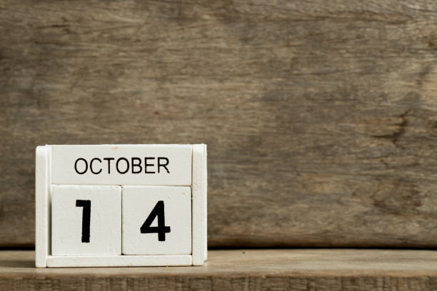 White block calendar present date 14 and month October on wood background