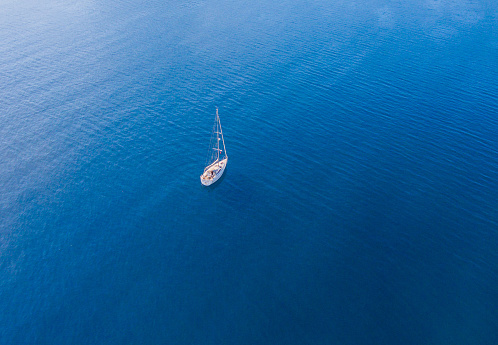 A lone sailing boat at anchor. The view from the air. Drone photo