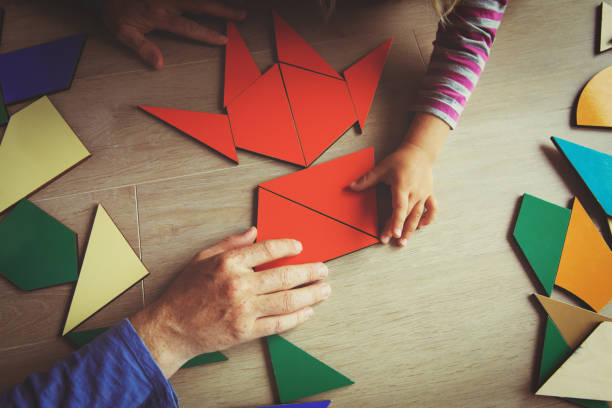 istock teacher and child playing with geometric shapes 857025098
