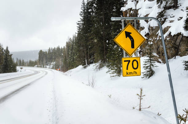 istock Speed Limit Sign along a Winding Mountain Road Covered in Snow 857025360