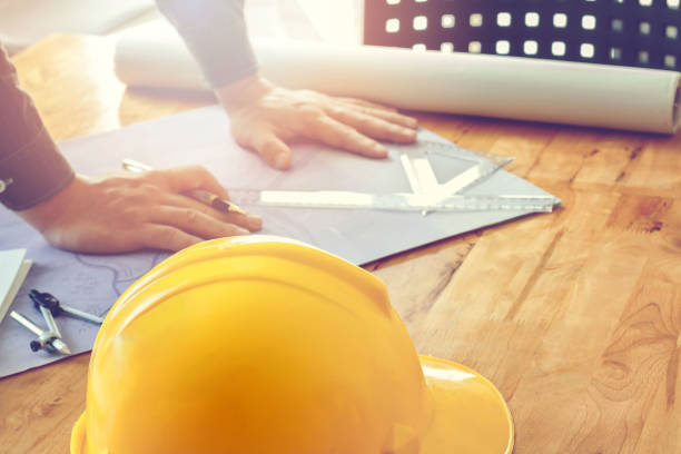 istock helmet on wooden desk with architect background 857028836