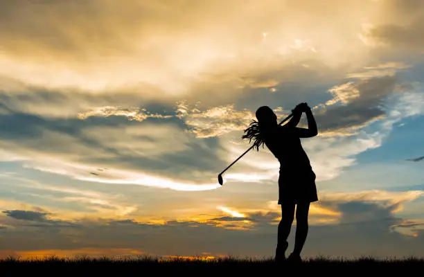Photo of silhouette golfer playing golf during beautiful sunset