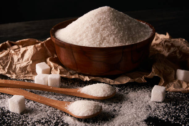 istock Bowl and spoon full of white sugar and sugar cubes 857032634