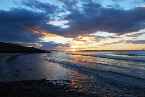 puesta de sol de bamburgh, northumberland, reino unido - bamburgh northumberland england beach cloud fotografías e imágenes de stock