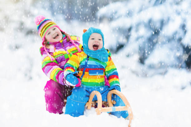 istock Kids on sleigh ride. Children sledding. Winter snow fun. 857036228