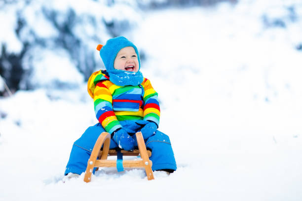 istock Boy on sleigh ride. Child sledding. Kid with sledge 857037460